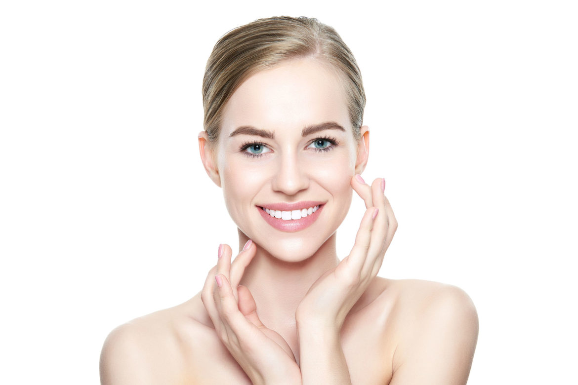 Beautiful Young Blond Woman with Perfect Skin touching her face. Facial treatment. Cosmetology, beauty and spa concept. Isolated on white background.