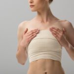 cropped view of woman with breast bandage